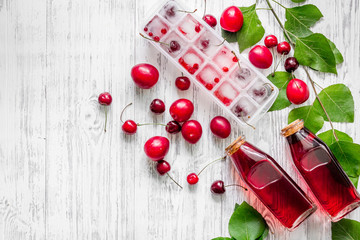 Summer ice tea with cherry and pulm on wooden table top view copyspace