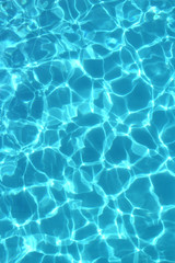 Fototapeta na wymiar Texture of clear blue water in the swimming pool