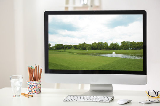 Workplace with computer monitor and wallpaper of landscape on screen