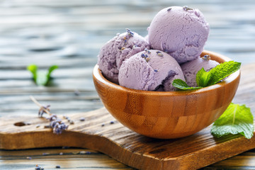 Homemade lavender ice cream in a wooden bowl.