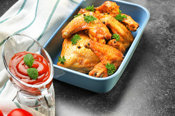 Delicious wings with sauce for chicken on kitchen table