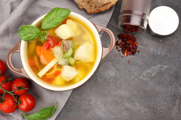 Composition with homemade turkey soup in casserole on table