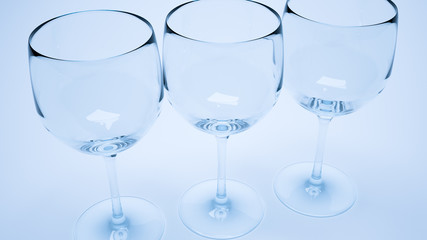 3d render of closeup of three wine glasses with blue light
