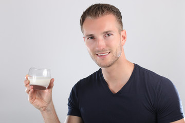 Bel homme tenant un verre de lait 