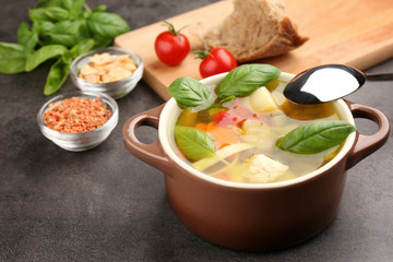 Composition with homemade turkey soup in casserole on table