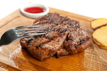 Delicious grilled steak on wooden board in restaurant