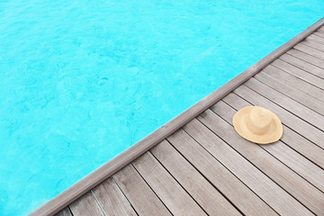 Fototapeta na wymiar Hat on wooden pontoon at sea resort. Summer vacation concept