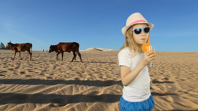 Young caucasian girl drink orange juice. Young girl in sahara desert feeling thirst. Very hot warm climat in desert. Fresh juice of orange fruit drinking walking in hat summer day.