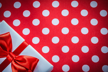 White gift box with knot on polka-dot red fabric celebrations co