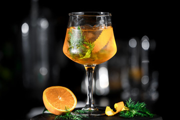 Yellow aperol drink cocktail with orange on black background