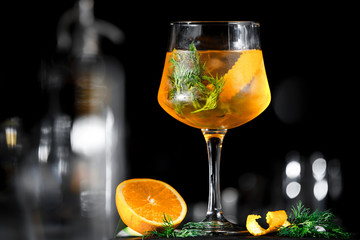 Yellow aperol drink cocktail with orange on black background