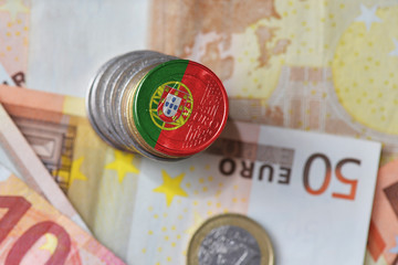 euro coin with national flag of portugal on the euro money banknotes background. © luzitanija