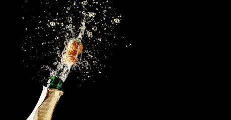 Fototapeta Champagne cork popping and splashing on black background obraz