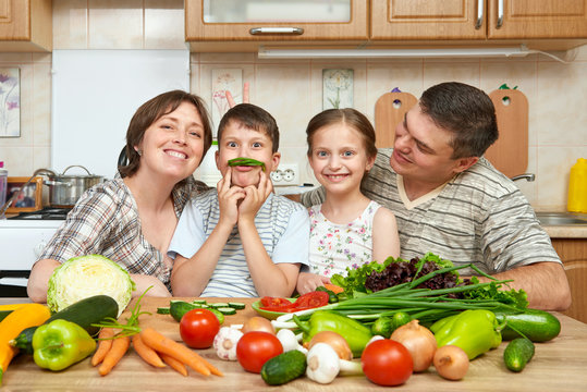 family portrait in kitchen interior at home, fresh fruits and vegetables, healthy food concept, woman, man and children cooking and having fun