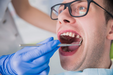  man sitting at a dentist's office at a dentist's office without one tooth