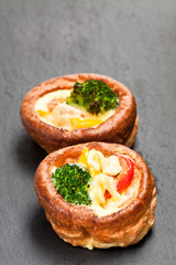 Yorkshire  puddings stuffed with broccoli and scrambled eggs on black stone background