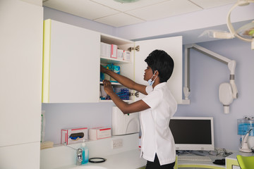 Obraz premium African dentist put or take something in stone