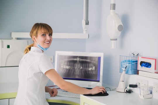 Image of female doctor looking at dental x-ray on the screen.