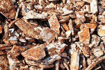 Part of a stone pile of rocks for construction and boulders piled, close up. Brown Granite. A large pile of limestone in quarry. Pile of gravel and construction material.