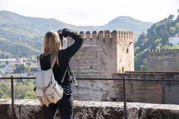 Young woman photographing Alhambra, Granada