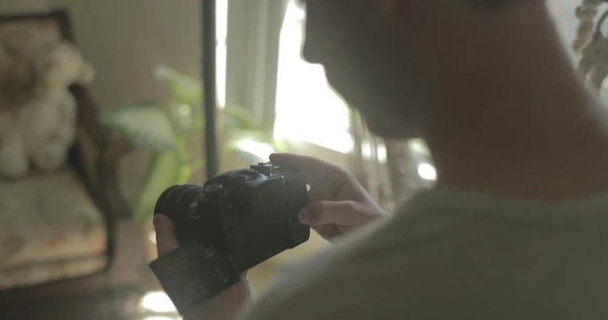 Man uses a digital camera at home for hobby photography.