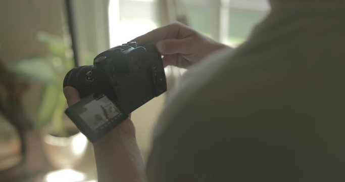 Man uses a digital camera at home for hobby photography.