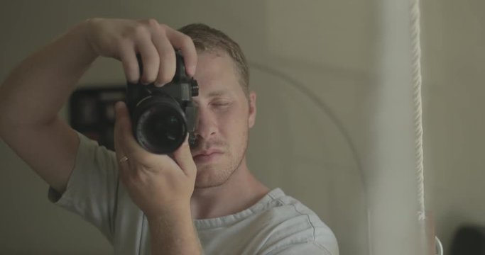 Man uses a digital camera at home for hobby photography.