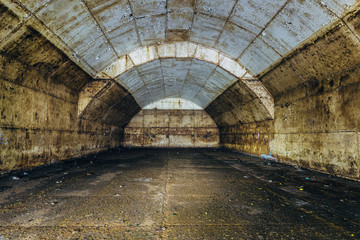 Fototapeta na wymiar Inside big rusty underground abandoned fuel tank for refueling diesel submarines at repair factory 