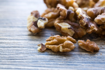 A handful of peeled walnuts on a gray board