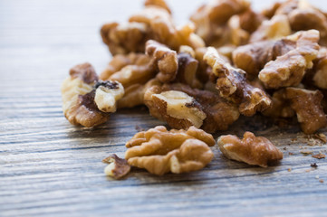 A handful of peeled walnuts on a gray board