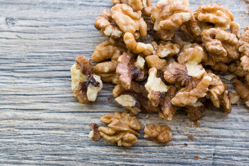 A handful of peeled walnuts on a gray board