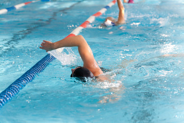 Swimming Man with black and white swimming cap in a row