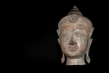 Buddha head. Classic traditional zen buddhism statue isolated against black background.