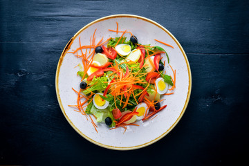 Vegetable salad with chicken eggs. On a wooden background. Top view. Free space for your text.
