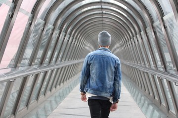 Homme urbain marchant dans un tunnel de verre