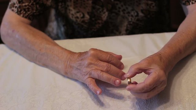 Grandmother takes off the wedding ring. Recollection of the deceased husband