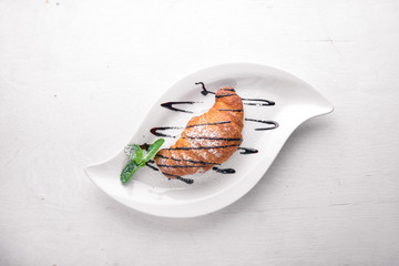 Croissant. On a wooden background. Top view. Free space for your text.