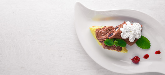 Chocolate creamy cream sponge. On a wooden background. Top view. Free space for text.