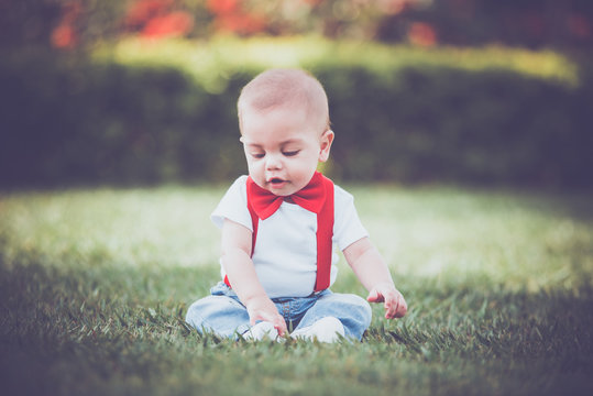 Vintage baby boy with red suspender and bow tie in outdoor