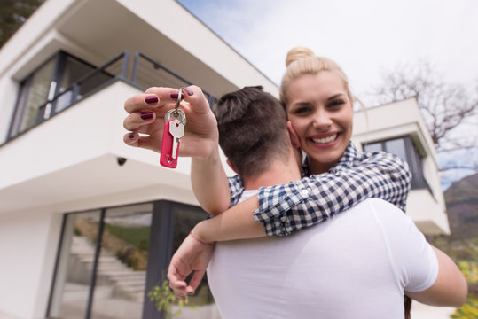 couple hugging in front of  new luxury home