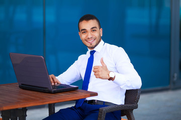 Business man at work. Portrait of young man wearing eyeglasses with laptop at cafe. Office, business concept