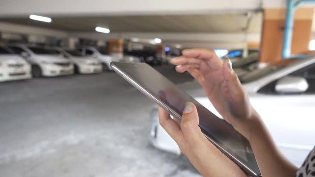 woman use digital tablet at car park background