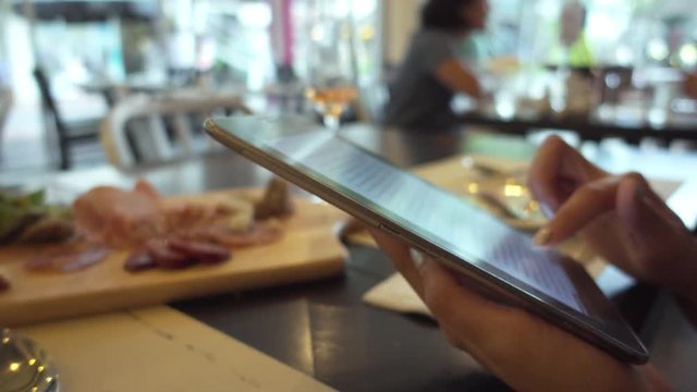 woman use digital tablet in restaurant close up shot