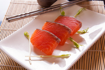 salmon sashimi on white dish on table background