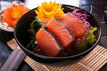 salmon sashimi on black dish on table background