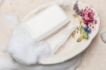 Fototapeta na wymiar Soap bars in vintage soap dish with floral decor