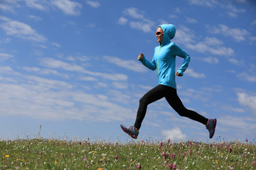 young fitness woman runner running on grassland