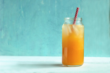freshly-squeezed orange juice with ice on a pastel blue background.