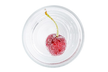 Close up the red ripe cherry in soda water around with bubbles of carbon dioxide on white background.