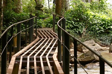 Steel bridge with sridith waterfall in tropical rain forest